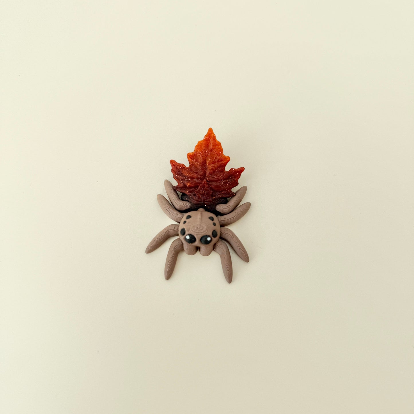 Compact 6 cm spider with freely moving legs and subtle textured ridges for tactile stimming.
