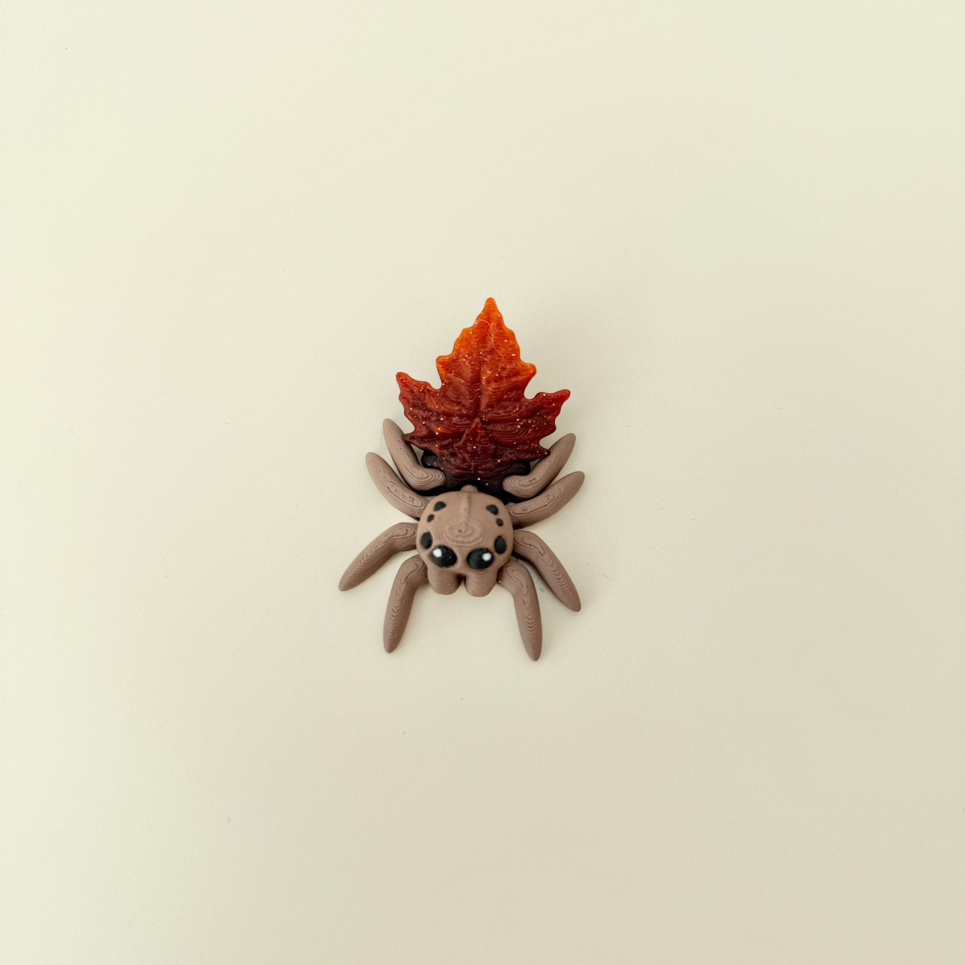 Compact 6 cm spider with freely moving legs and subtle textured ridges for tactile stimming.

