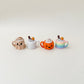 Mini mug clicker with cream topping and keyring loop for portable fidgeting.
