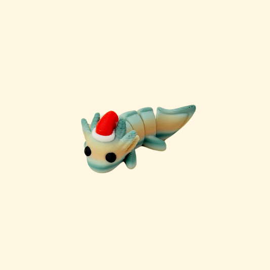 Mini articulated axolotl fidget with red Christmas hat in muted tones.
