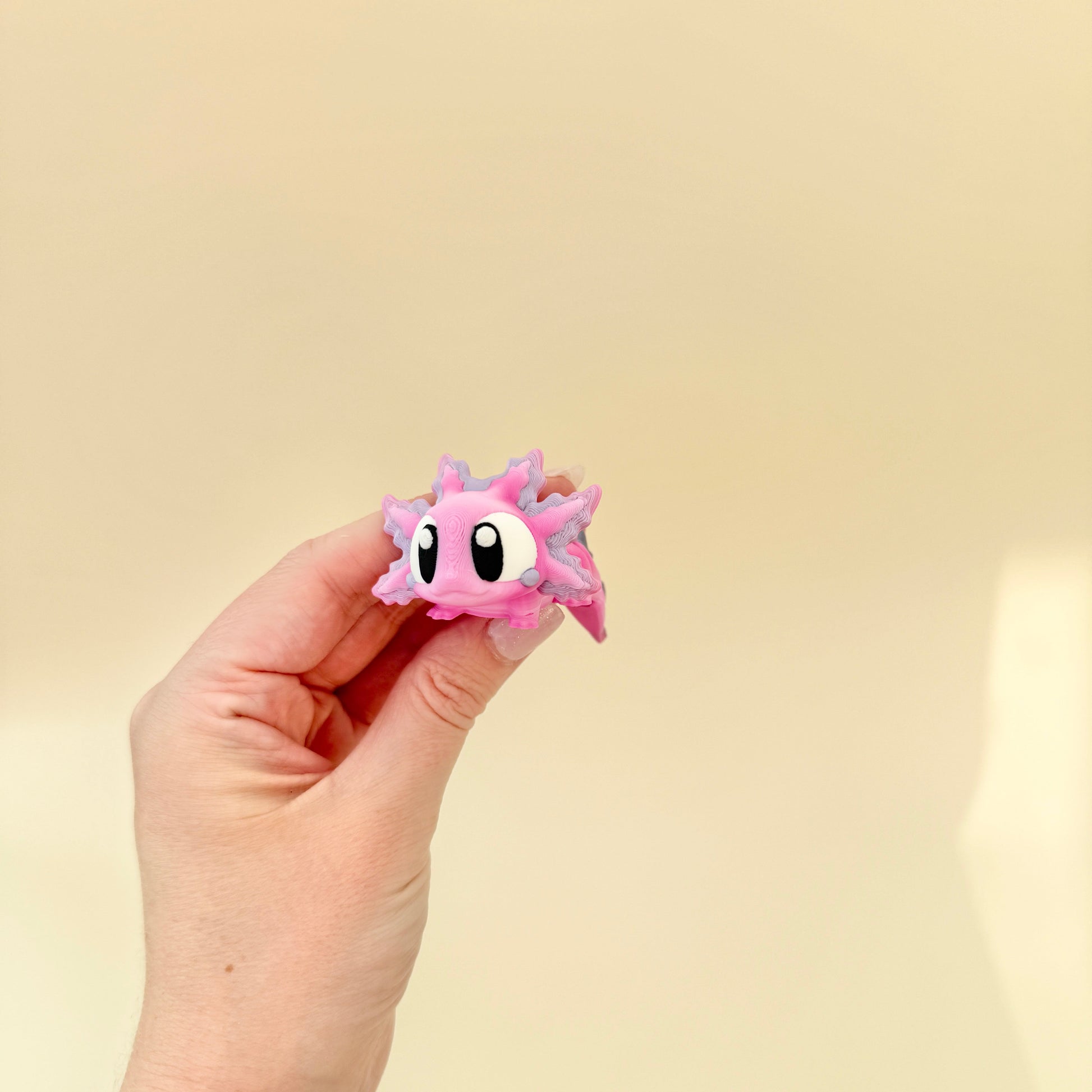 Adorable pink and white gradient axolotl with lilac shimmer, perfect for gentle sensory play.
