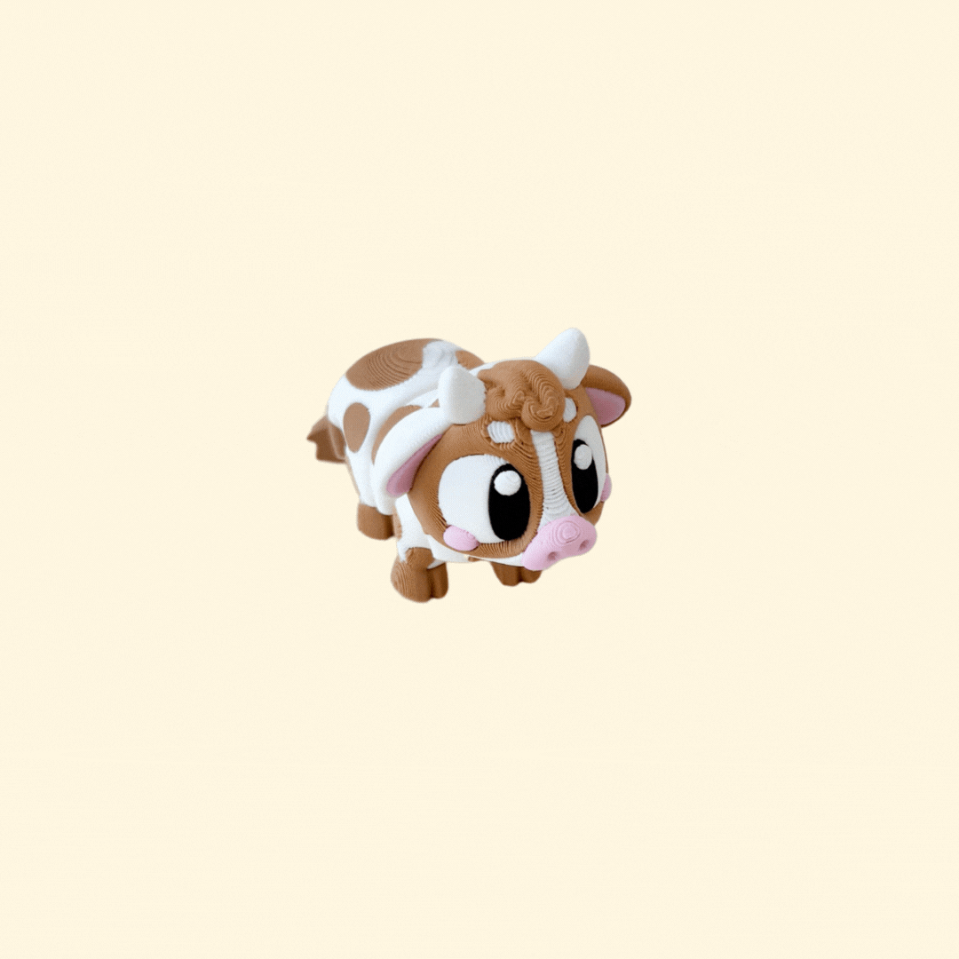 A fully articulated baby cow fidget toy with brown and white markings, horns, and big black-and-white eyes.