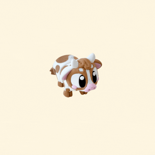 A fully articulated baby cow fidget toy with brown and white markings, horns, and big black-and-white eyes.