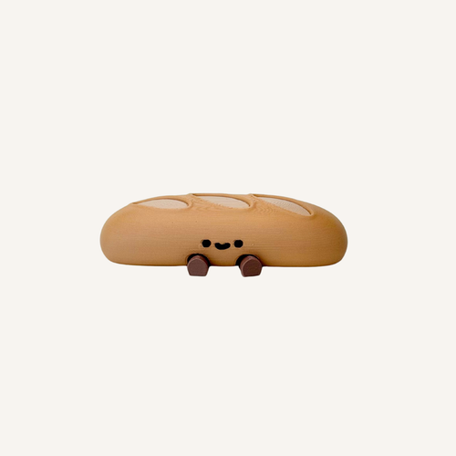 Cute mini baguette character with dangling legs designed for desks, shelves and cosy decor in neuro-friendly spaces
