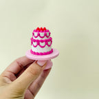 compact tiered cake fidget with single-click action and raised decoration

