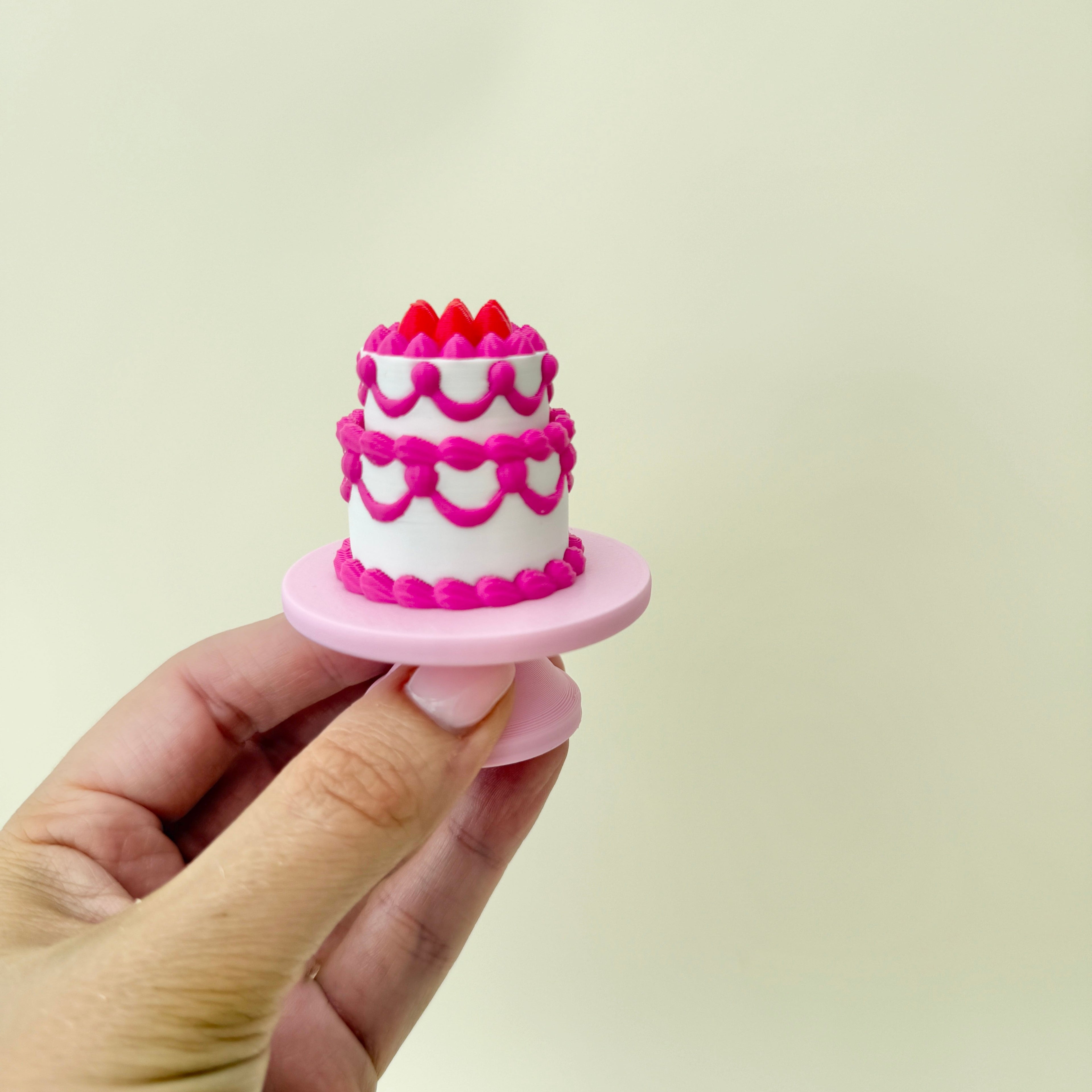 compact tiered cake fidget with single-click action and raised decoration
