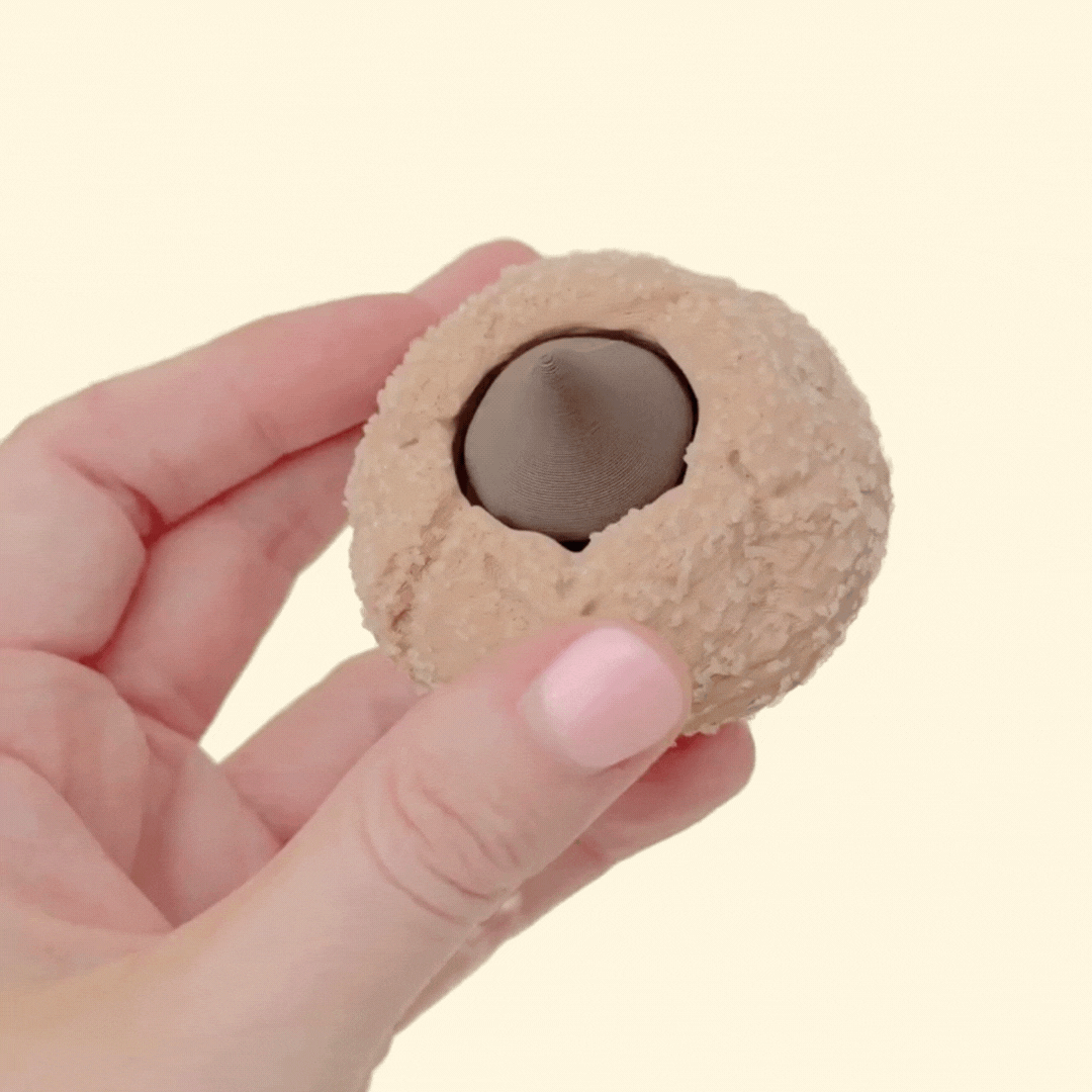 A handheld novelty clicker with raised texture and a central press button for repetitive fidgeting.
