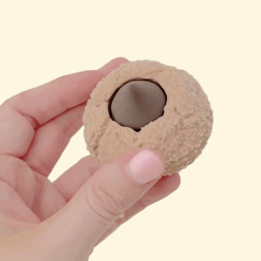 A handheld novelty clicker with raised texture and a central press button for repetitive fidgeting.
