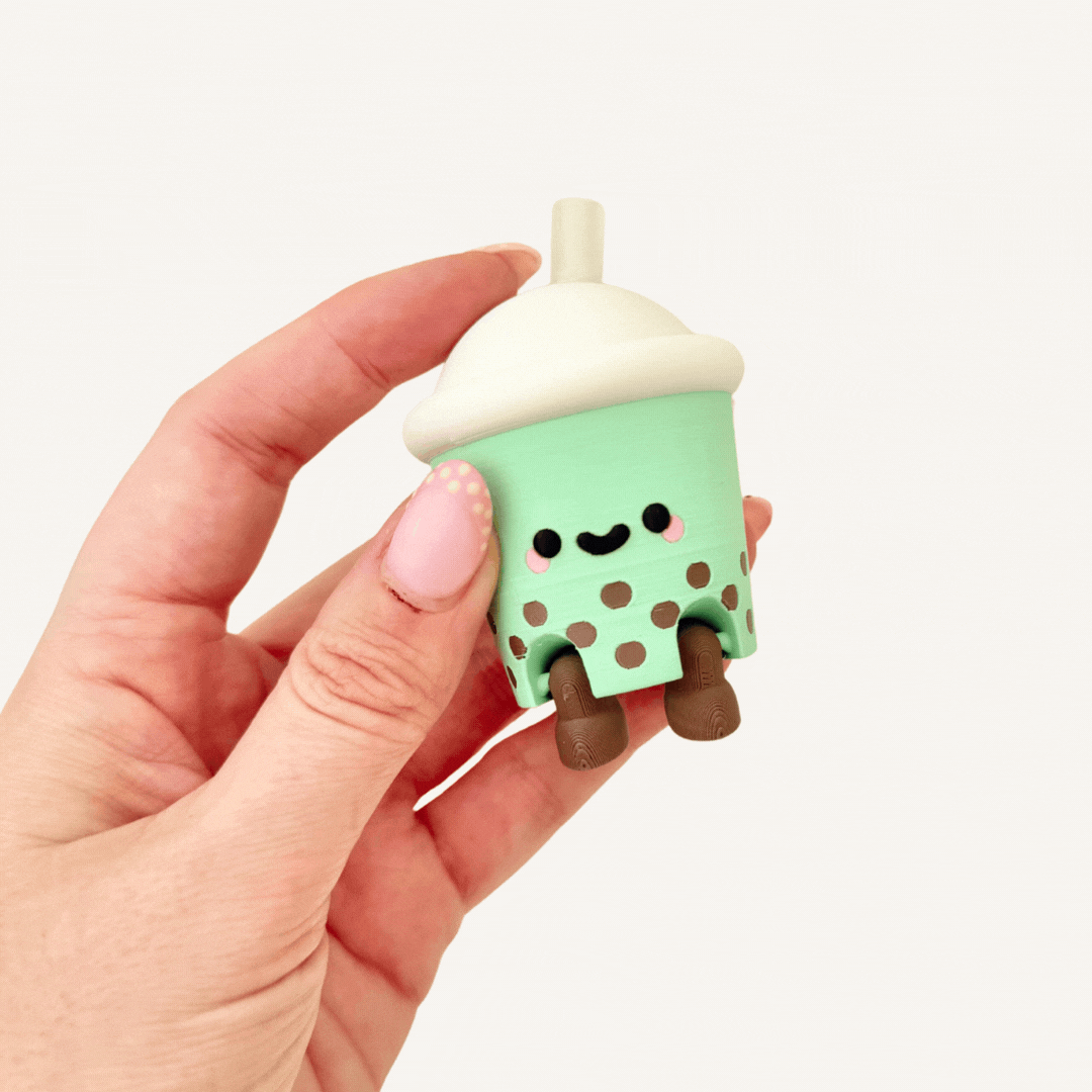 Cute boba tea cup clicker fidget with wiggly legs and a press-down lid for sensory focus.

