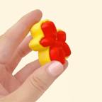 Small balloon dog-shaped clicker fidget toy in red and yellow with a tactile surface.