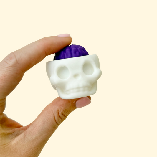 Small skull-shaped fidget toy with a clickable brain for sensory play
