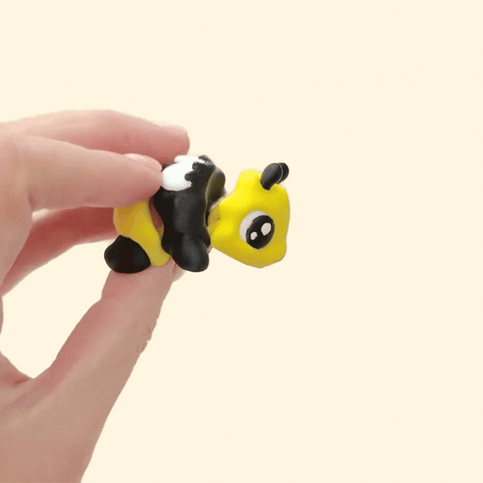 A 5cm articulated bee fidget toy with a happy expression and detailed colouring.