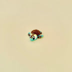 Gradient green and yellow baby turtle fidget with brown textured features.