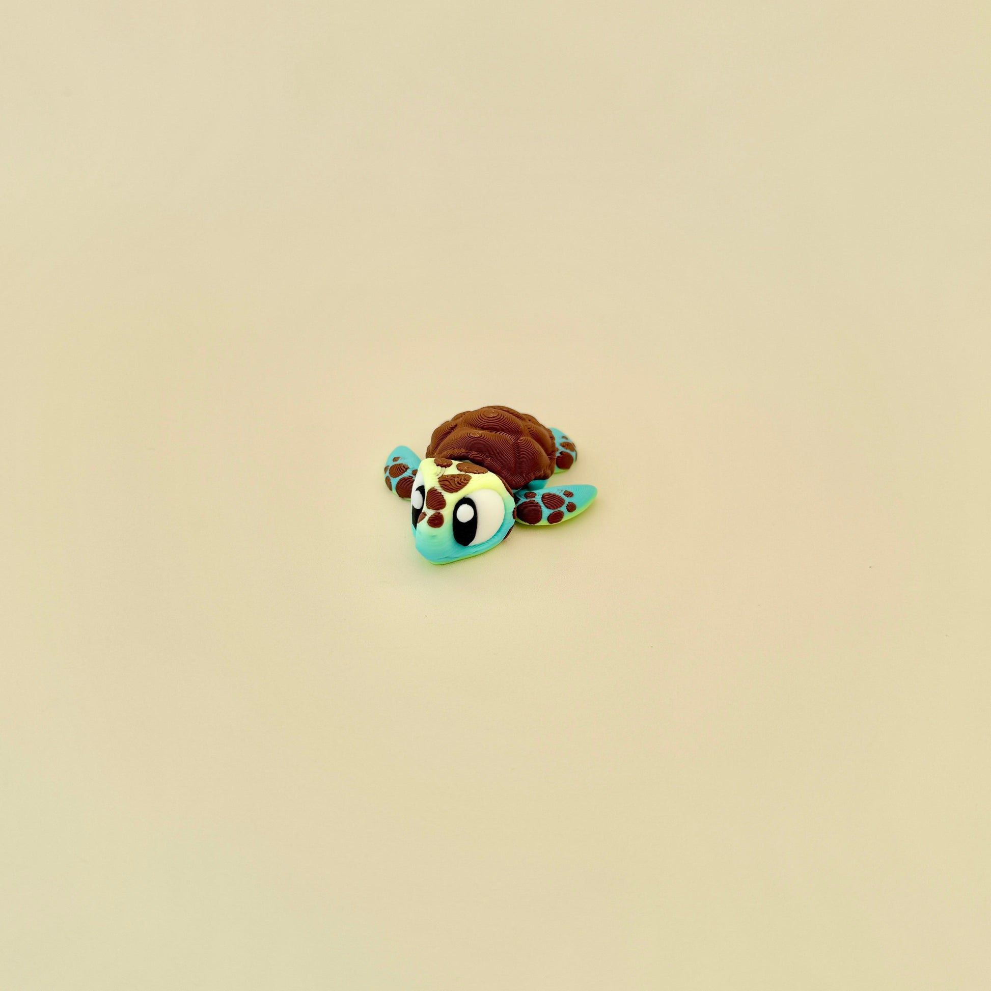 Gradient green and yellow baby turtle fidget with brown textured features.