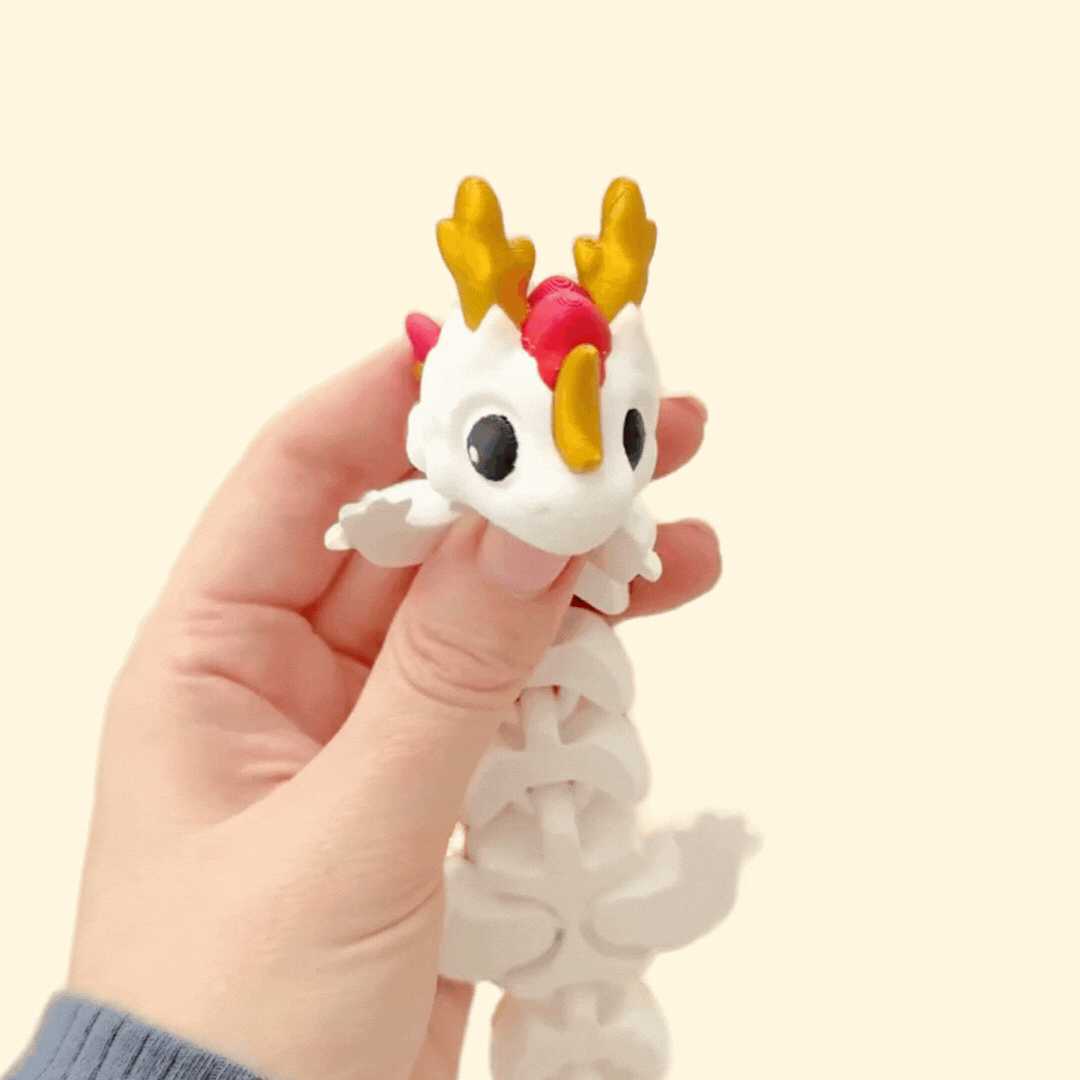 Articulated Lunara dragon fidget toy featuring dreamy stars, moons, and cloud-like wings.
