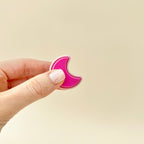 Bright and pale pink crescent moon clicker toy, perfect for stress relief and focus.