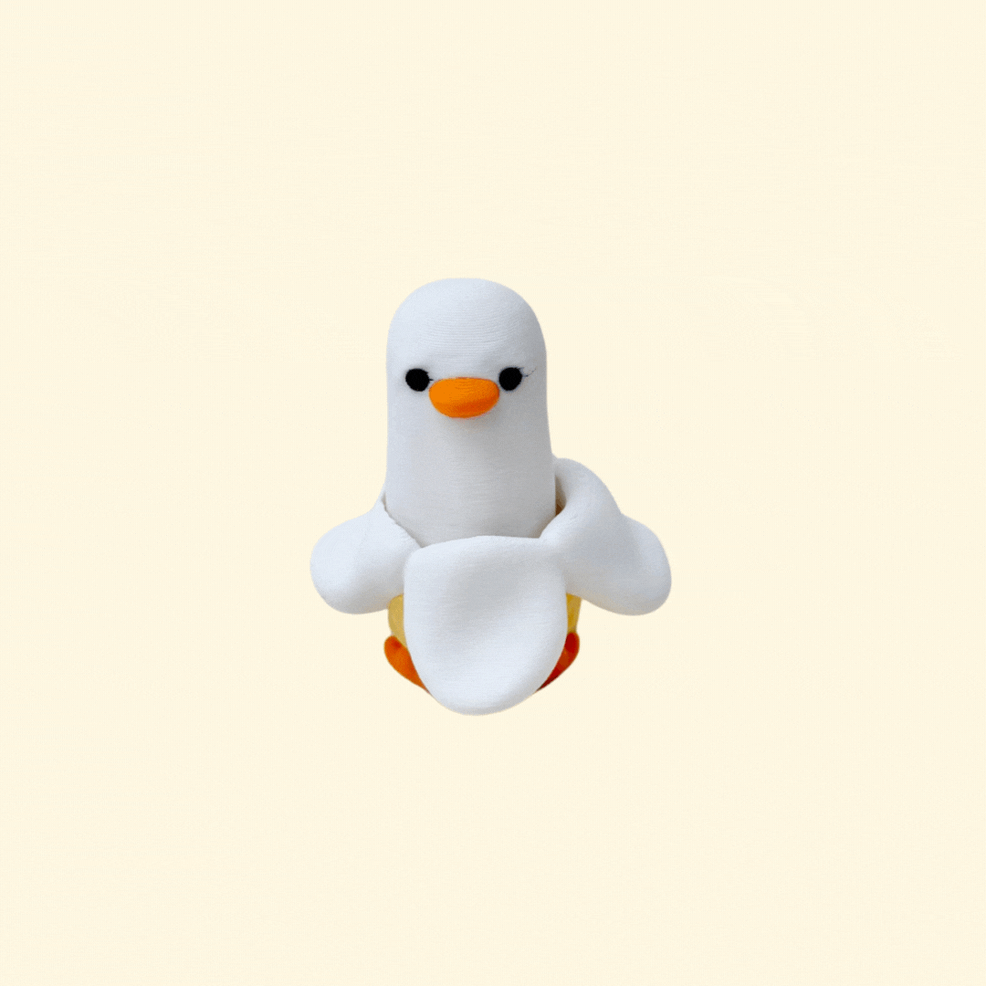 Small banana duck clicker fidget with a press-down action designed for tactile sensory input and playful stress relief.
