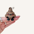 Cute poop-shaped keyring charm with dangly legs for lanyards, bags or keys, designed as a funny desk buddy.
