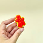 Red balloon-style dog fidget toy with a smooth, raised surface and click function.
