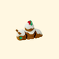 Pudding-brown articulated snail with white frosting and holly topper.
