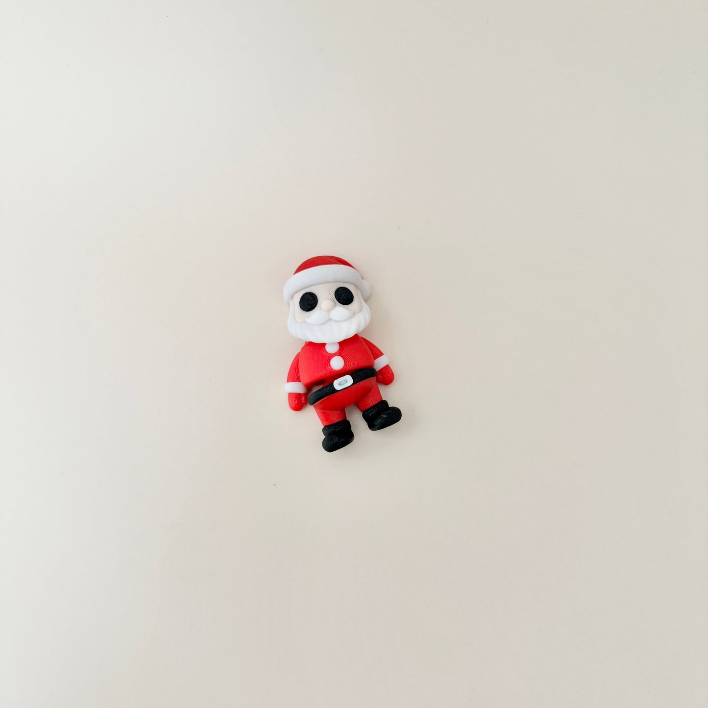 Santa fidget toy with articulated arms and legs, dressed in a red suit with a white beard and hat.