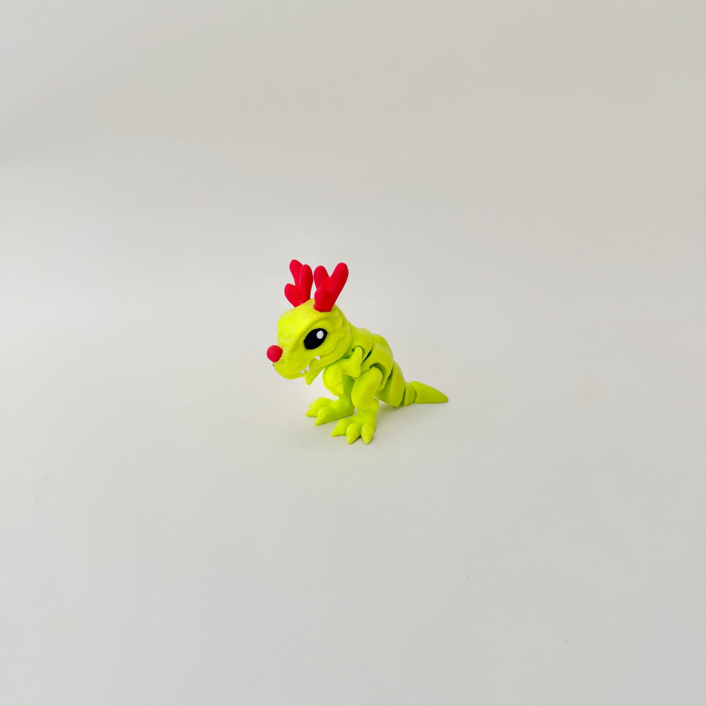 Lime-green articulated dinosaur, cosy handheld size, tactile texture for stimming and focus.
