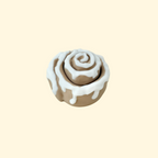 Cinnamon roll-inspired fidget clicker with swirled design and white icing.