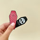 Two-piece magnet split in hand; one red textured side and one skull “flip” side.
