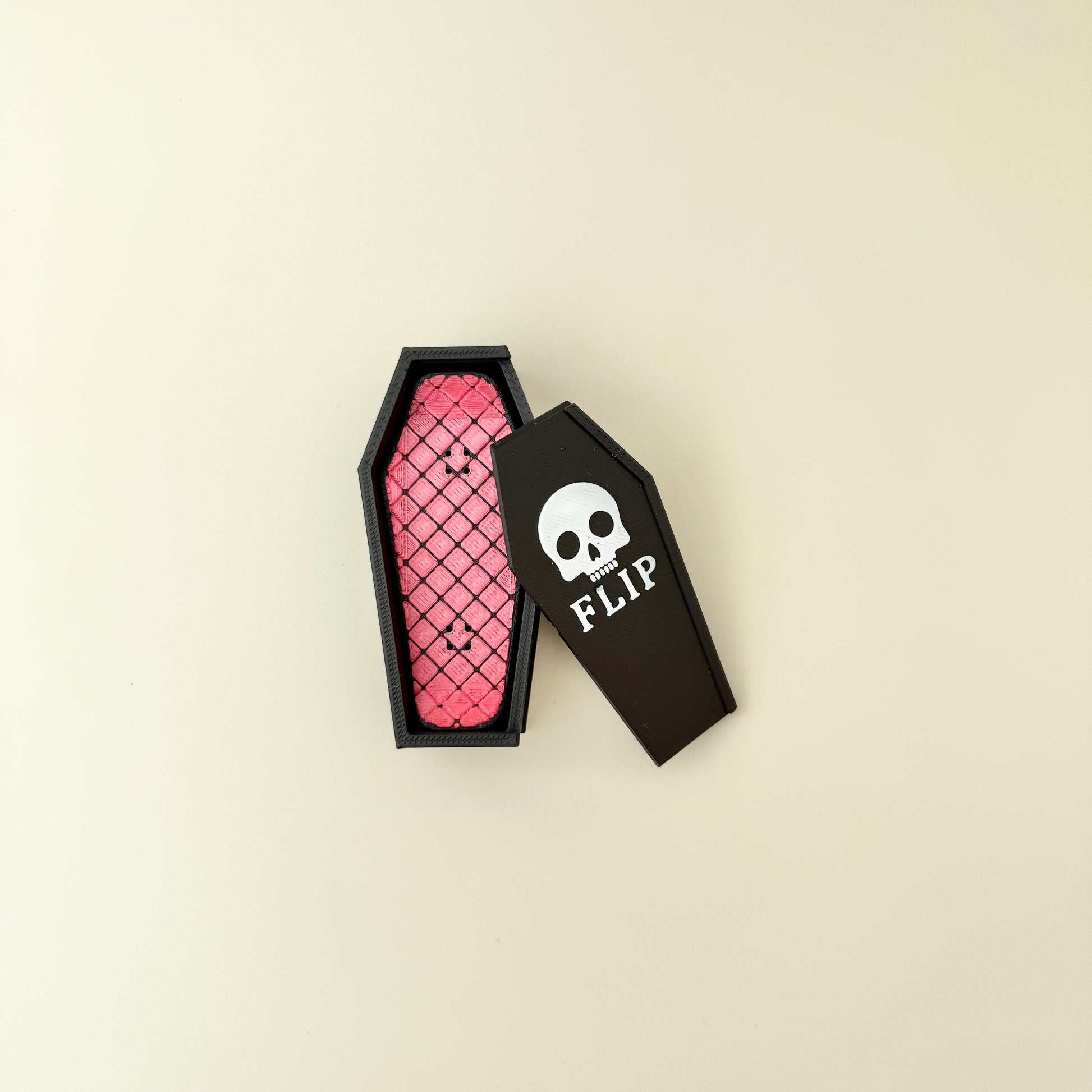 Handheld magnetic snap fidgets with coffin-shaped storage case on neutral background.
