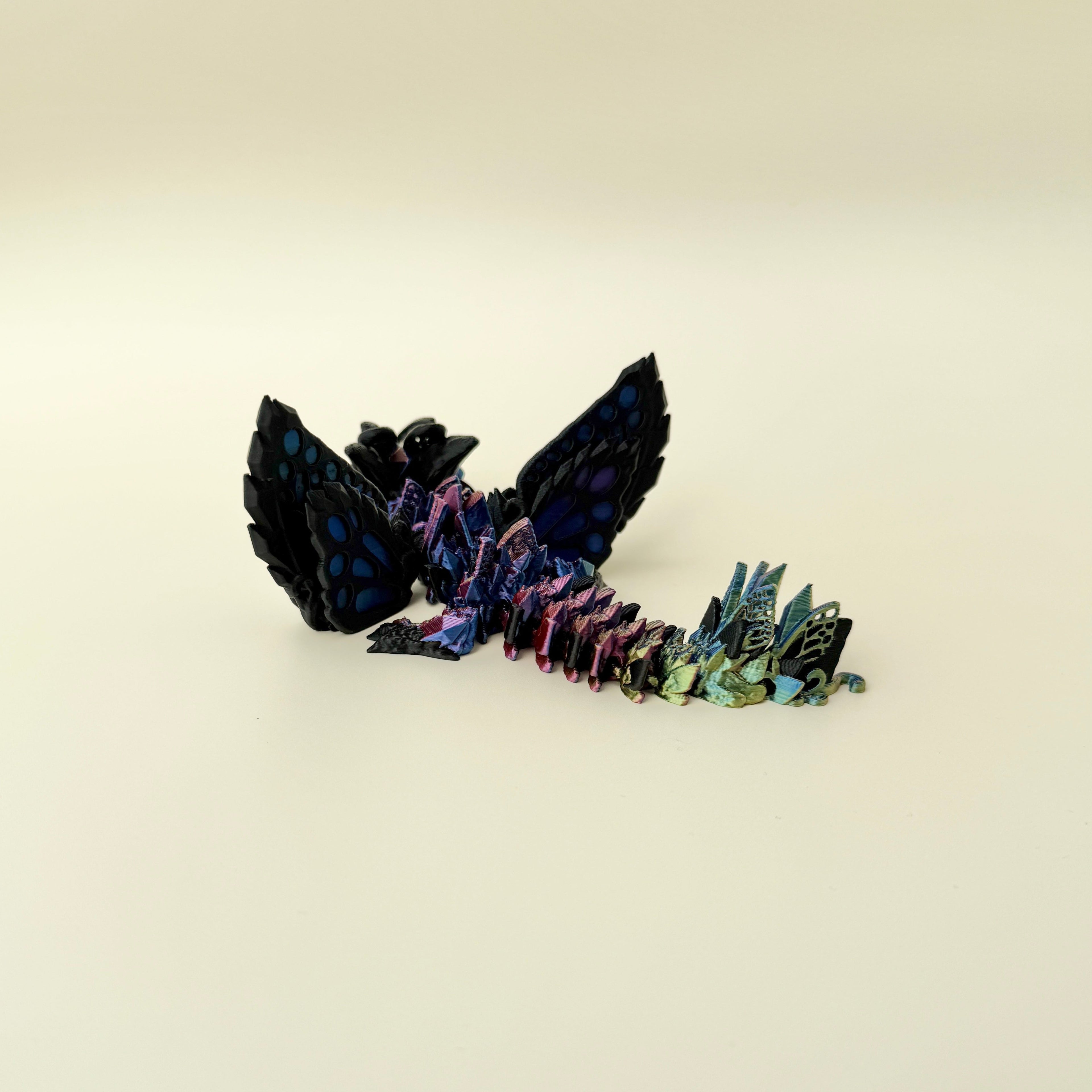 Hybrid dragon-wolf fidget toy with shifting metallic colour and butterfly elements