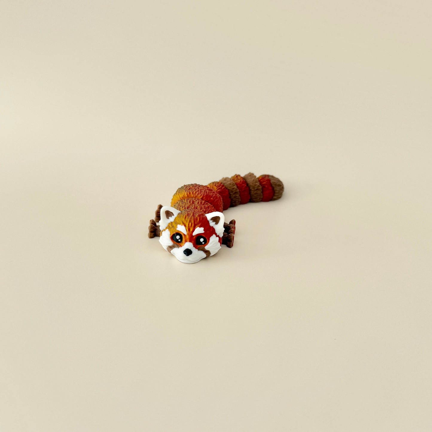 A collectable red panda fidget toy with intricate details, white facial markings, and a colour-changing filament.