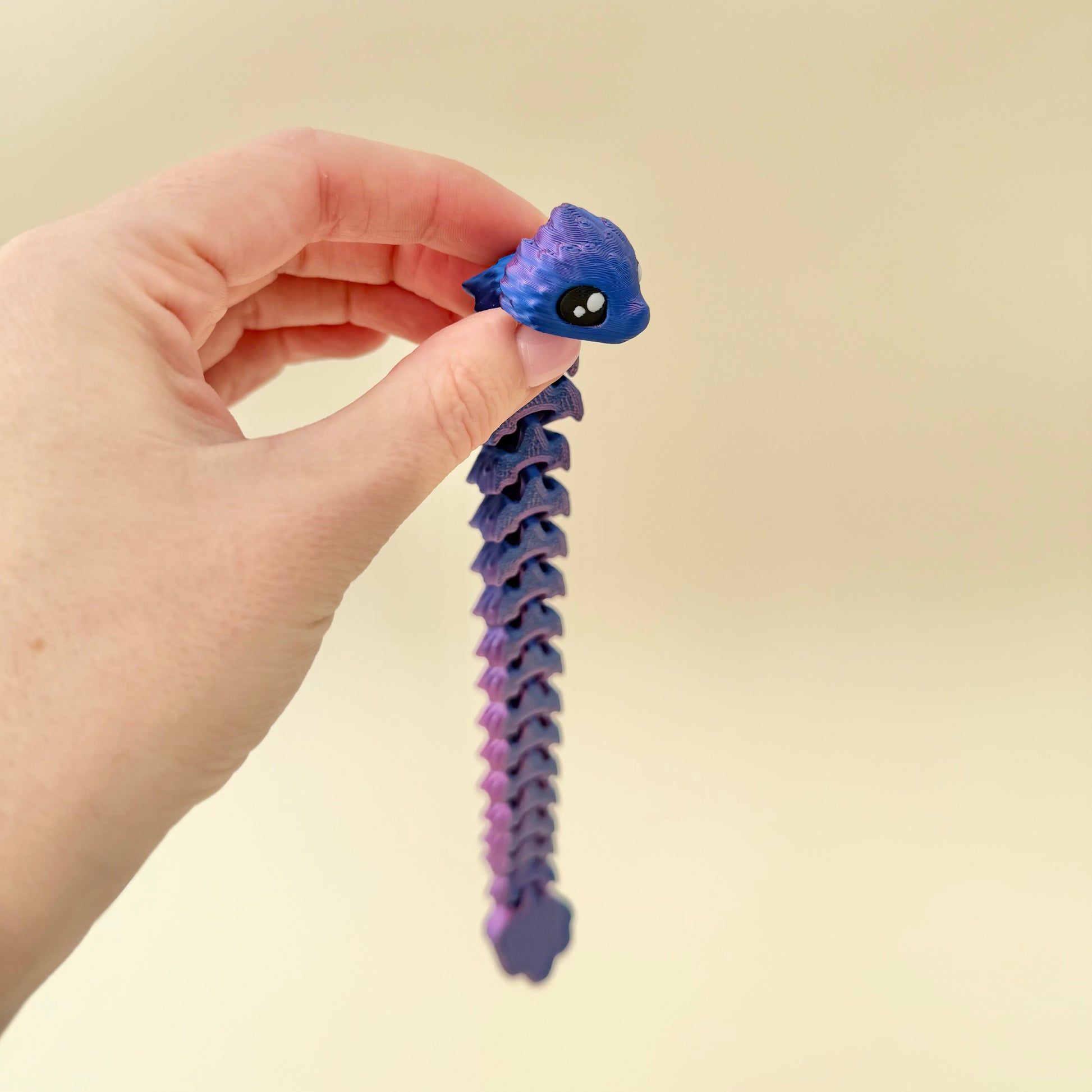 Cool-toned filament that changes hue with light and motion; low-noise fidget toy.
