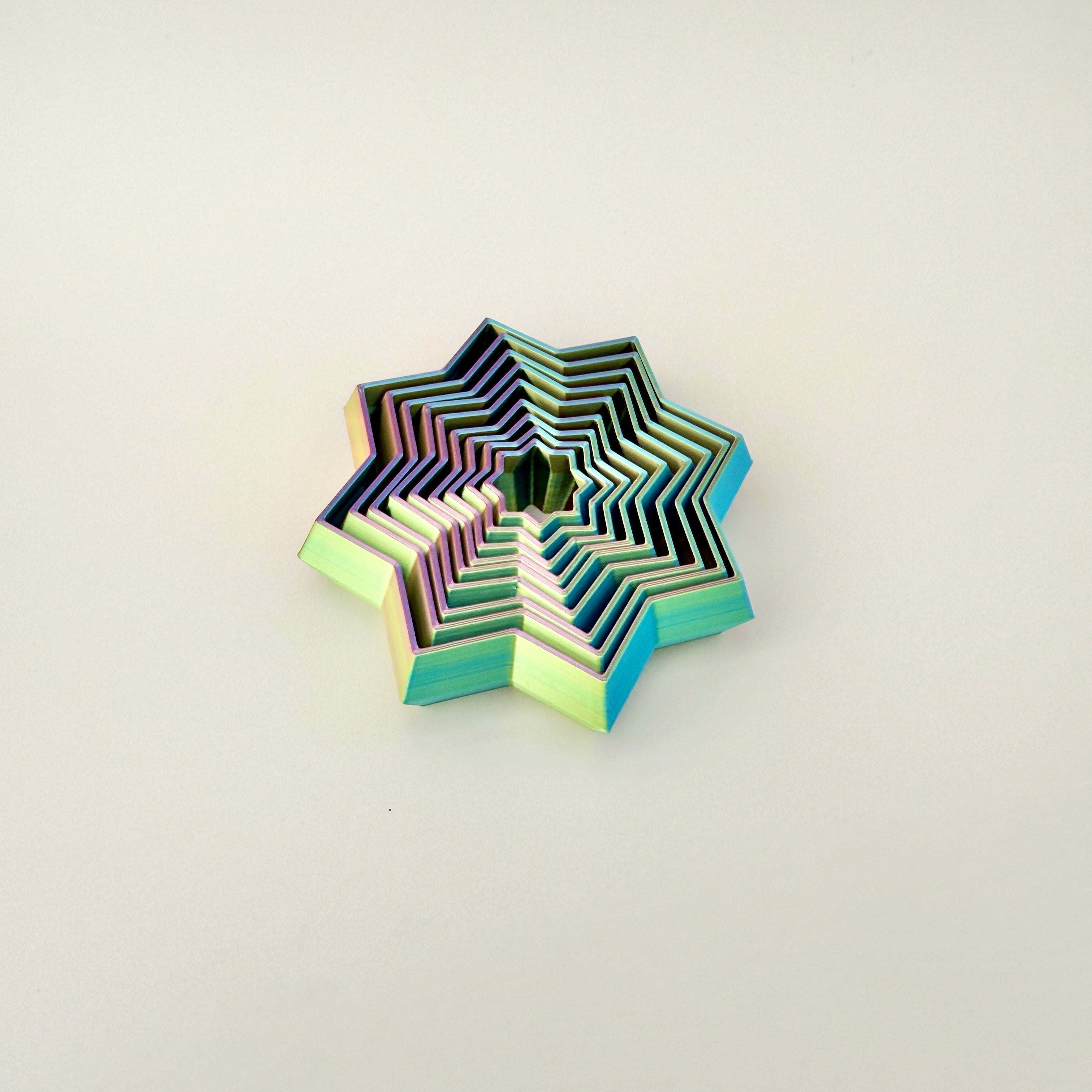 A vibrant, colour-changing star fidget toy with intricate layered details.