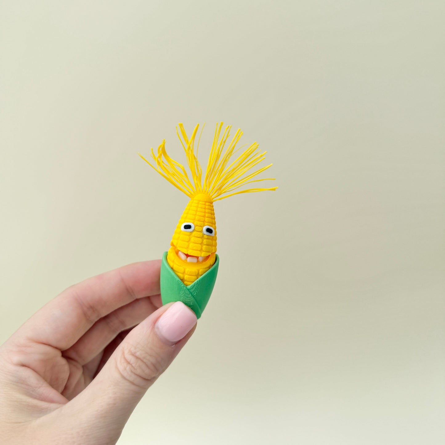 Two corn-themed fidget toys with hinged mouths and textured kernels, supplied with a small dish.
