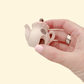 Mini teapot-shaped fidget with a press-to-click lid and neutral cottage details.
