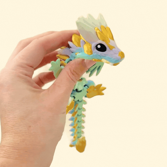 A dragon fidget toy featuring a soft rainbow colour shift with a shimmering gold finish.