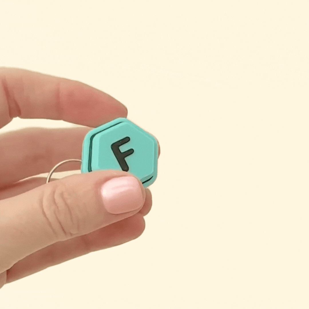 A small, personalised fidget keyring with a raised letter, ideal for stress relief and focus.
