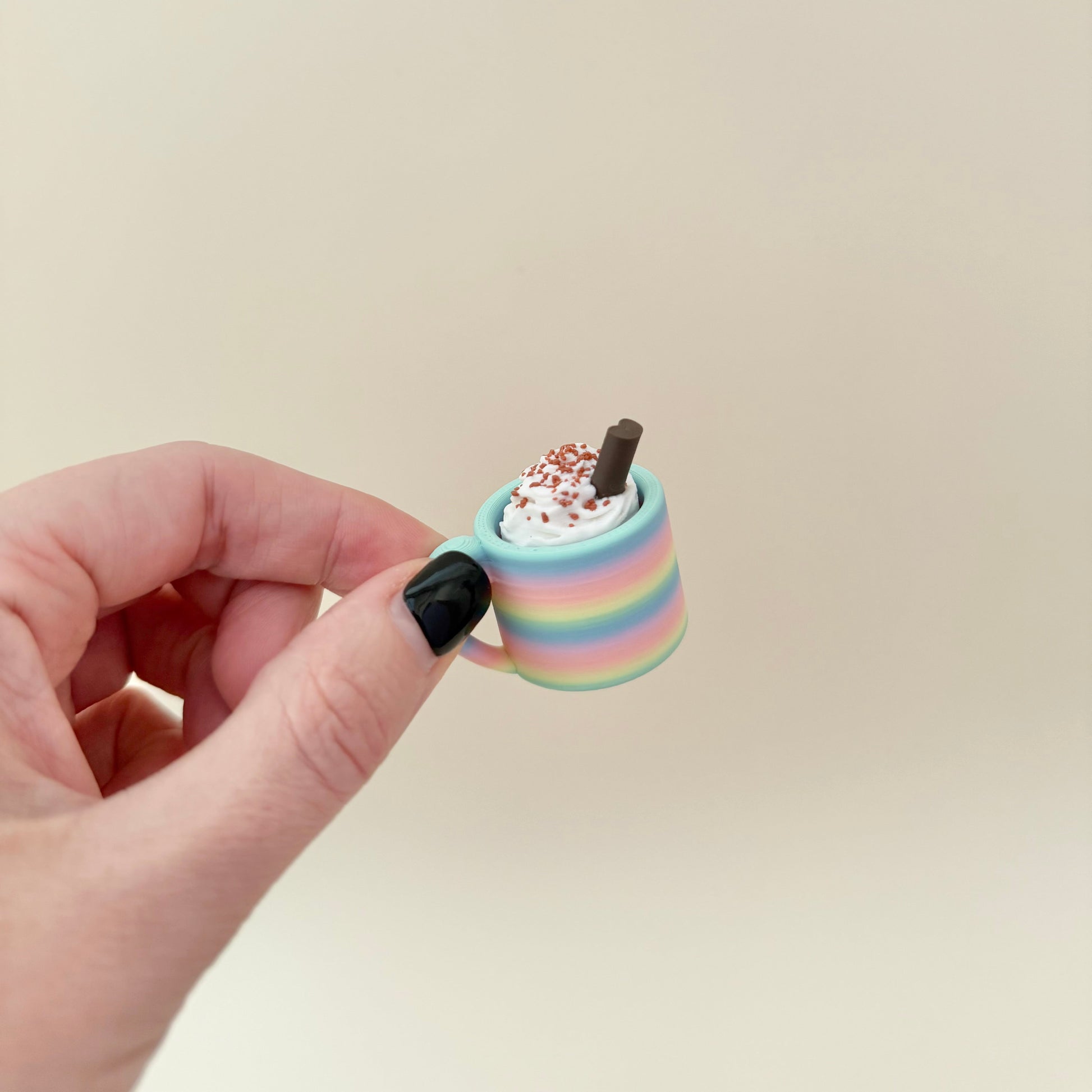 Mug-shaped sensory fidget with whipped top; choose colour, topping and click or quiet; portable desk-friendly size.
