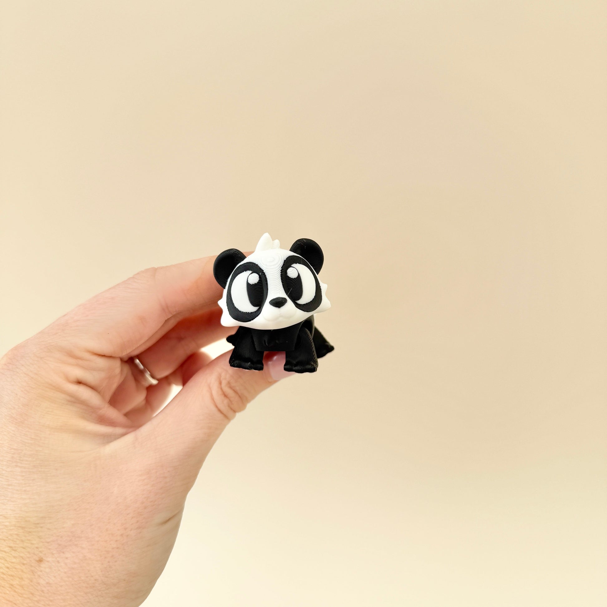 A black and white baby panda toy with big expressive eyes, perfect for fidgeting, display, or gifting.