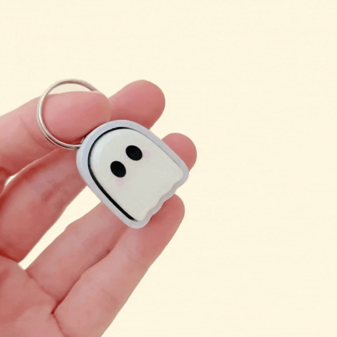 Small sparkly ghost clicker keyring with frosted finish and pink cheeks