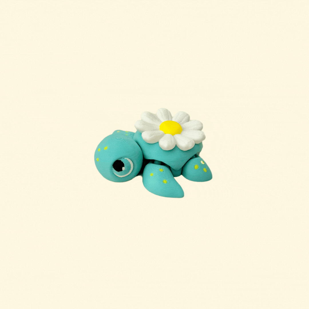 A 5cm teal fidget turtle with a yellow-speckled body and a daisy design on its shell.