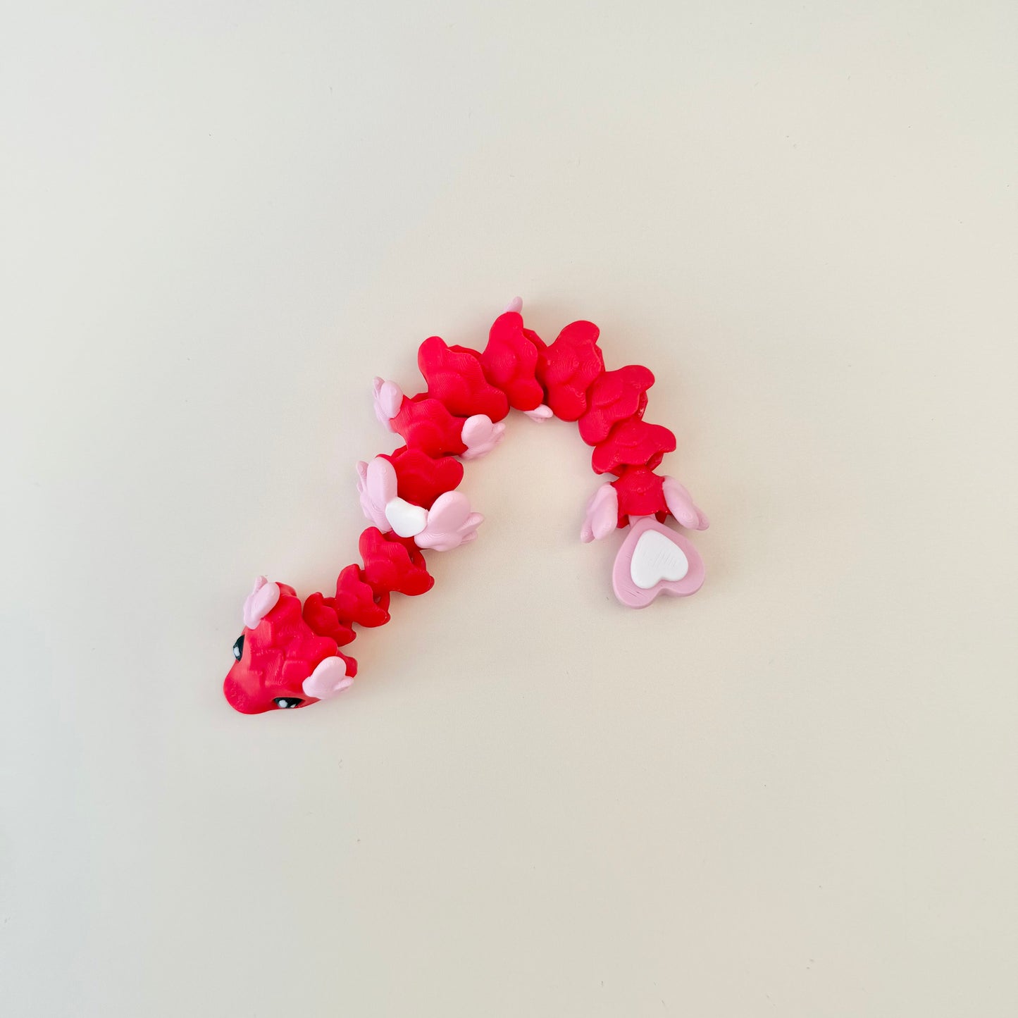 14 cm articulated serpent with gentle wiggle and heart tail; neurodivergent-friendly handheld fidget for focus and calm.
