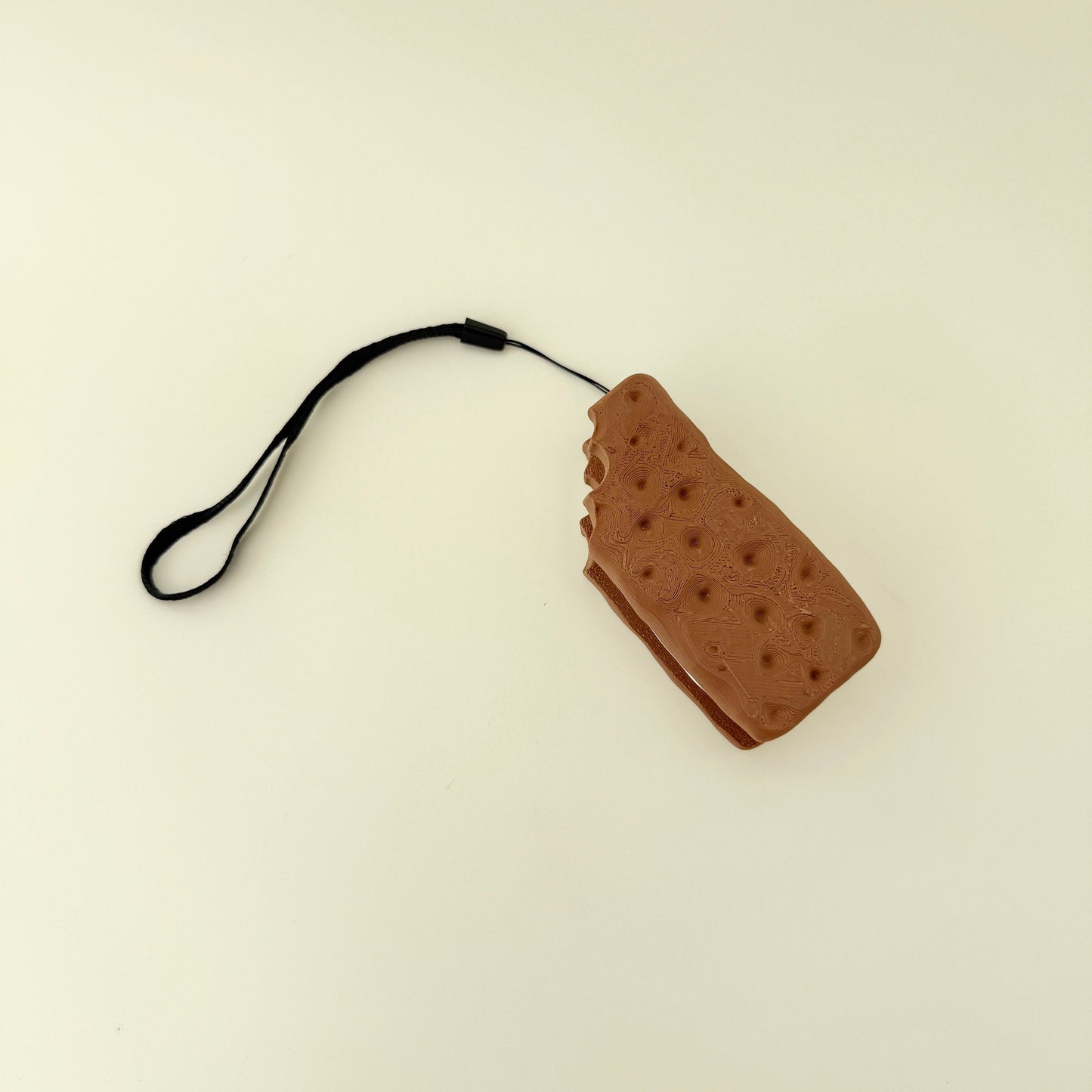 chunky handheld clicker fidget with ridged biscuit texture and soft centre
