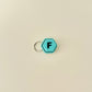 A compact hexagonal fidget toy that clicks when pressed, available with all 26 letters of the alphabet.