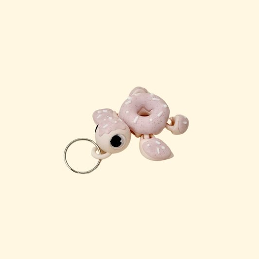 Doughnut-shaped turtle lanyard charm with smooth curves and textured detail for thumb tracing, grounding and busy hands.

