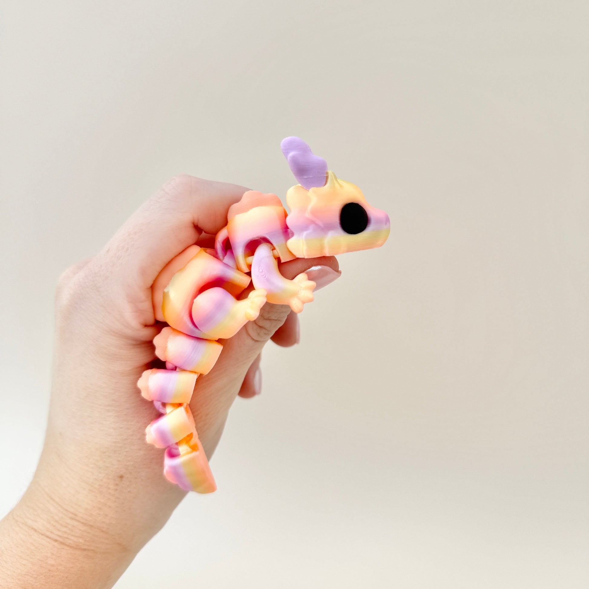 Articulated dragon fidget toy with intricate scales, gradient colours, and detailed features, perfect for sensory play.