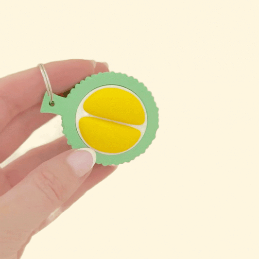Green durian-inspired clicker toy with textured shell and smooth clicking centre