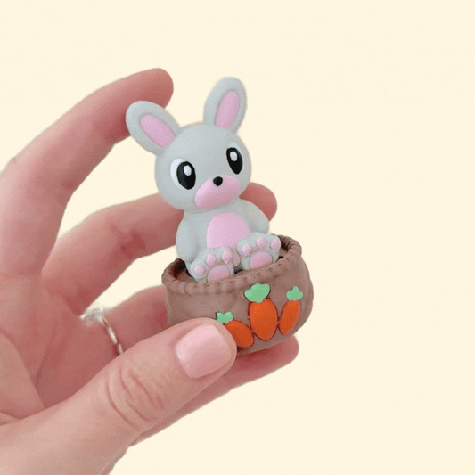 A chunky fidget clicker toy with a full-sized bunny on a basket, designed for sensory play.