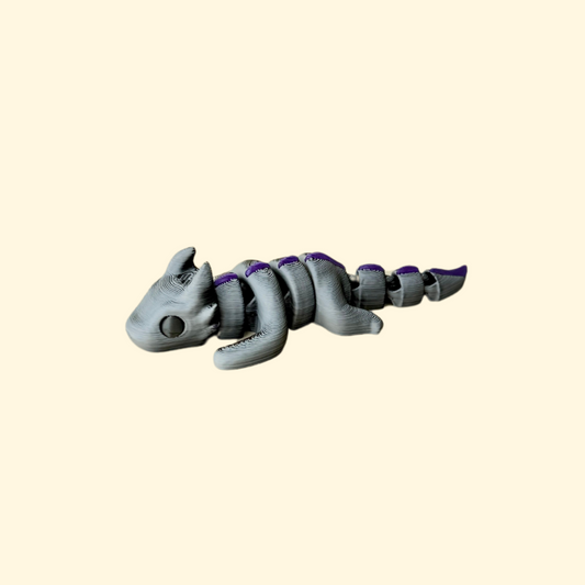 Flexible fidget dragon with metallic purple spikes and smooth segmented body for sensory play