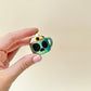compact cup-shaped clicker fidget with tactile eyeball press
